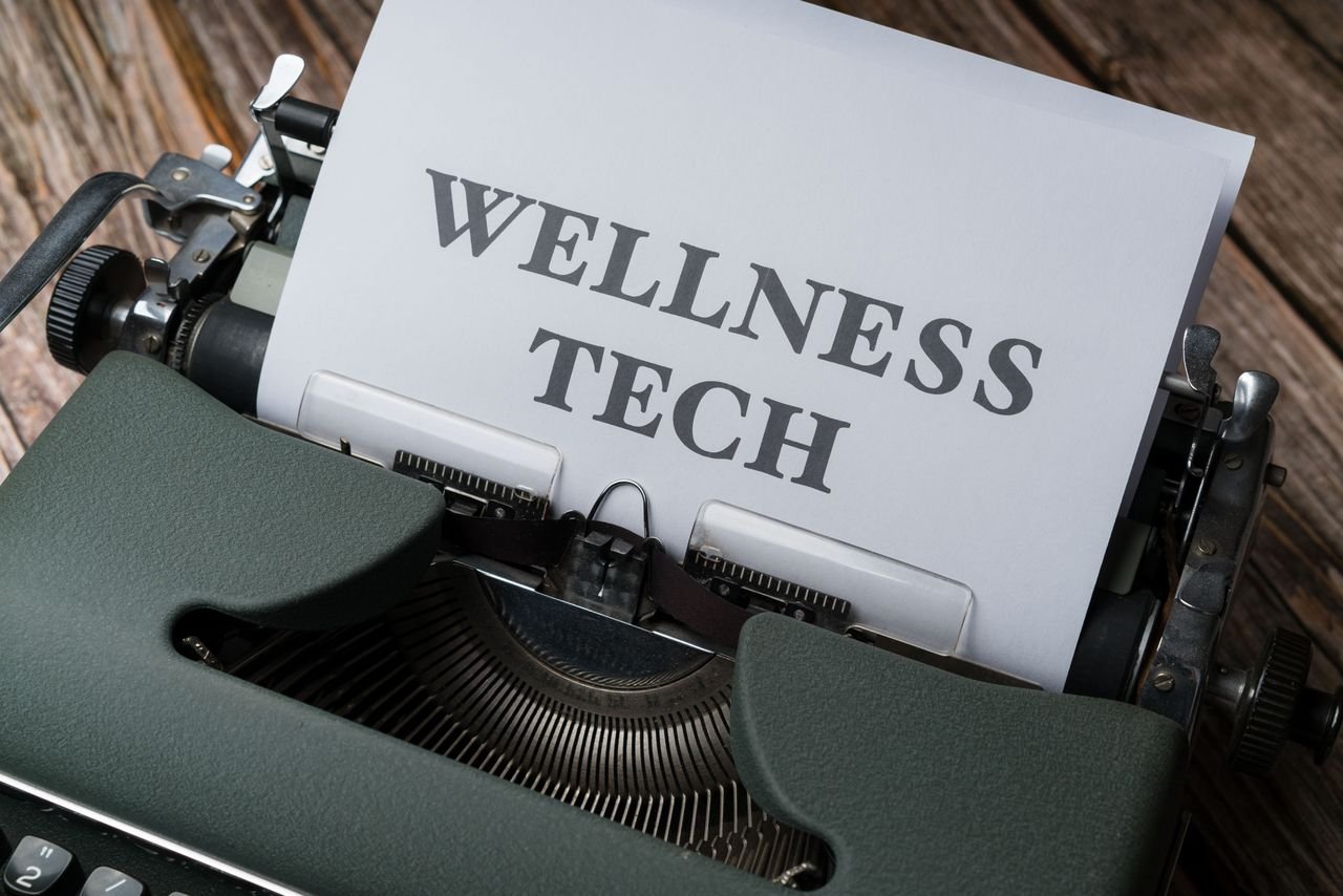 Home Close-up of a typewriter with paper displaying 'WELLNESS TECH'.